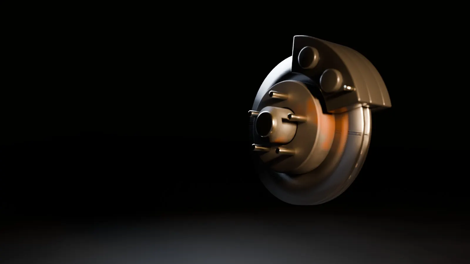A brake rotor, caliper and hub lit by an amber work light