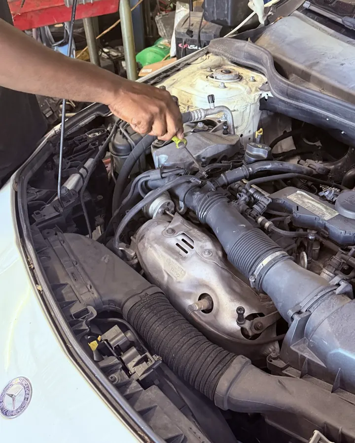 A technician testing an engine bay at Front Line Auto