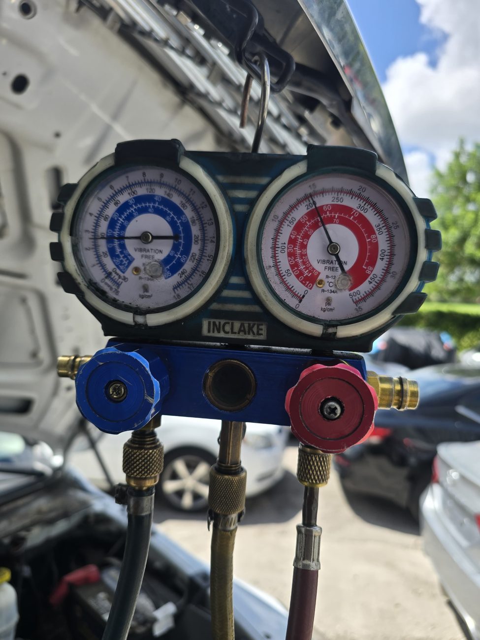 AC manifold gauges connected to a vehicle at Front Line Auto in Oakland Park