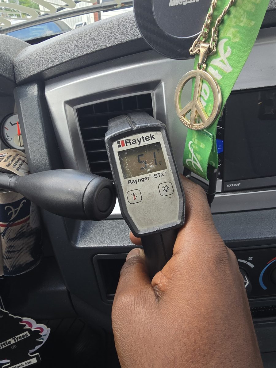 Infrared thermometer reading the air temperature at a dashboard vent at Front Line Auto