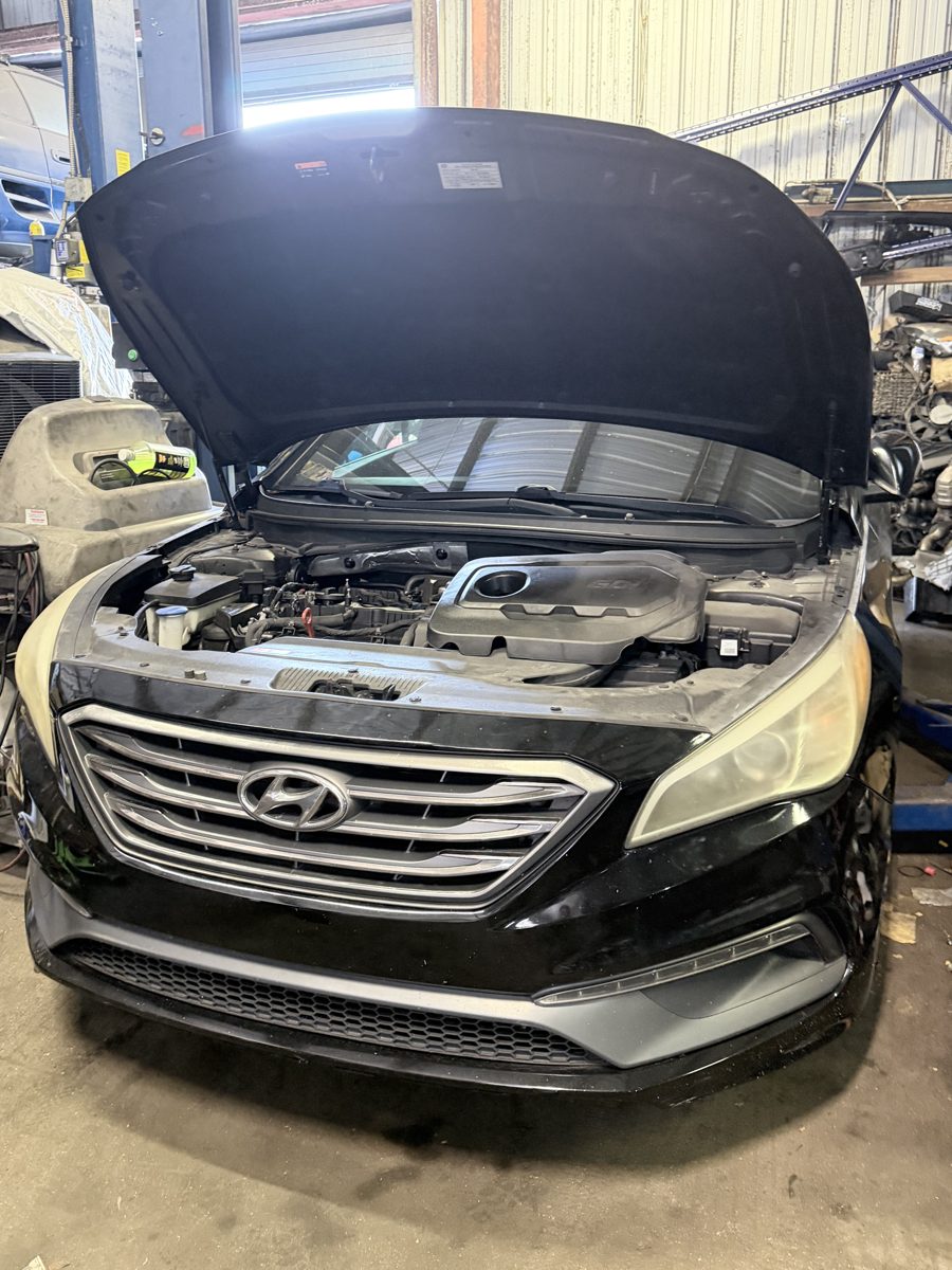 Front Line Auto technician with the hood open on a Hyundai Sonata in the Oakland Park service bay