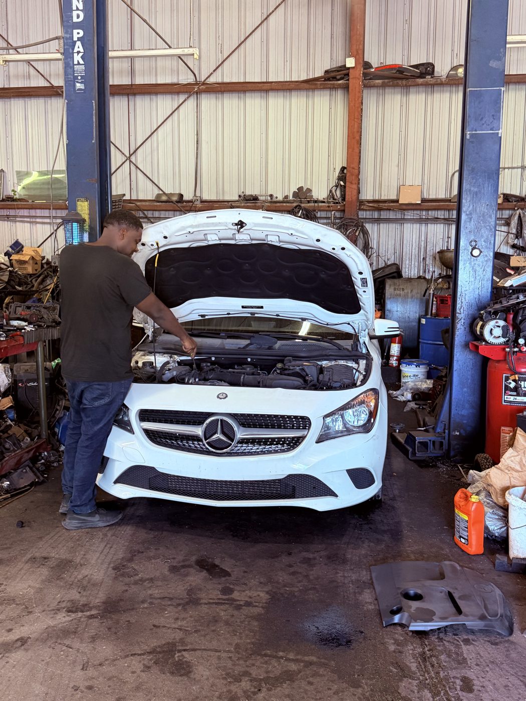 Vehicle with the hood open in the Front Line Auto service bay in Oakland Park, Florida