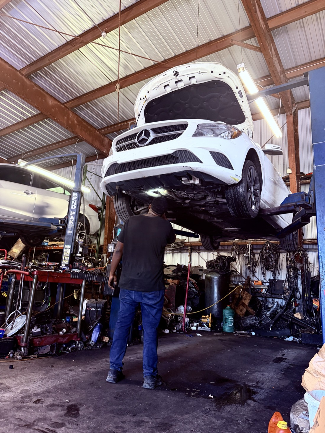 Mercedes-Benz vehicle raised on a lift at Front Line Auto in Oakland Park