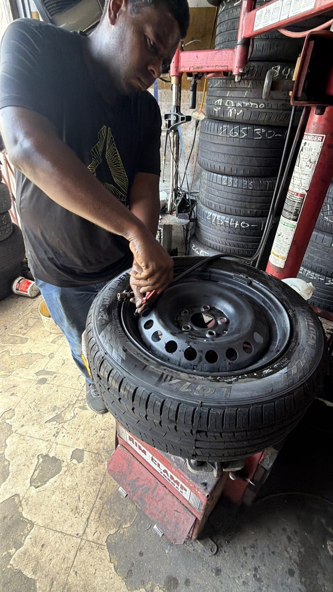 Front Line Auto technician mounting a tire in the Oakland Park service bay